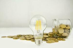 Business concept. Lamp with coins on a light background. Business ideas, brainstorming. Recovery and business growth. Copy space photo