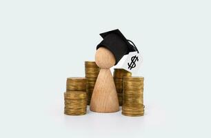 concepto de financiero educación y literatura. de madera hombre con un graduación sombrero y oro monedas en un ligero antecedentes foto