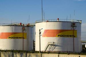 Reservoirs with fuel at the oil depot of Rosneft. Tanks in the light of the setting sun. photo