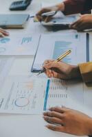 Financial analysts analyze business financial reports on a digital tablet planning investment project during a discussion at a meeting of corporate showing the results of their successful teamwork. photo