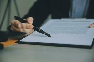 Business and lawyers discussing contract papers with brass scale on desk in office. Law, legal services, advice, justice and law concept picture with film grain effect photo