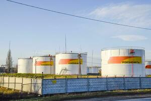 Reservoirs with fuel at the oil depot of Rosneft. Tanks in the light of the setting sun. photo