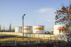 Reservoirs with fuel at the oil depot of Rosneft. Tanks in the light of the setting sun. photo