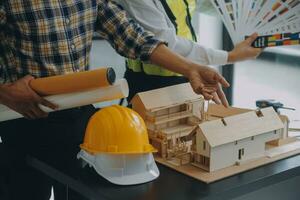 Construction and structure concept of Engineer or architect meeting for project working with partner and engineering tools on model building and blueprint in working site, contract for both companies. photo