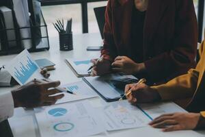 Financial analysts analyze business financial reports on a digital tablet planning investment project during a discussion at a meeting of corporate showing the results of their successful teamwork. photo