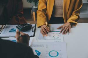 Financial analysts analyze business financial reports on a digital tablet planning investment project during a discussion at a meeting of corporate showing the results of their successful teamwork. photo