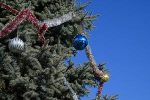 decoraciones nuevo año árbol. oropel y juguetes, pelotas y otro decoraciones en el Navidad Navidad árbol en pie en el abierto aire. foto