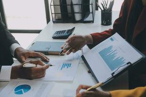 Financial analysts analyze business financial reports on a digital tablet planning investment project during a discussion at a meeting of corporate showing the results of their successful teamwork. photo