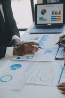 Financial analysts analyze business financial reports on a digital tablet planning investment project during a discussion at a meeting of corporate showing the results of their successful teamwork. photo