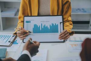 Financial analysts analyze business financial reports on a digital tablet planning investment project during a discussion at a meeting of corporate showing the results of their successful teamwork. photo