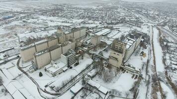 Grain terminal in the winter season. Snow-covered grain elevator in rural areas. A building for drying and storing grain. photo