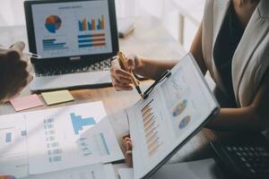 Close up of Business team analyzing income charts and graphs with modern laptop computer. Business analysis and strategy concept. photo