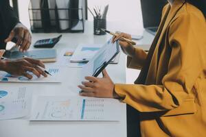 Financial analysts analyze business financial reports on a digital tablet planning investment project during a discussion at a meeting of corporate showing the results of their successful teamwork. photo