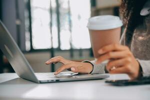 Asian businesswoman working on laptop computer Look for job online, freelance looking and typing on notebook on table, lifestyle of woman studying online photo