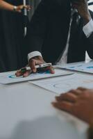 Financial analysts analyze business financial reports on a digital tablet planning investment project during a discussion at a meeting of corporate showing the results of their successful teamwork. photo
