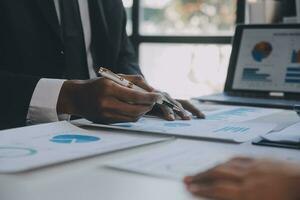 Financial analysts analyze business financial reports on a digital tablet planning investment project during a discussion at a meeting of corporate showing the results of their successful teamwork. photo
