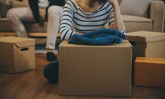 Two Asian blogger showing clothes in front of the camera to recording vlog video live streaming at her shop. Online Shopping Cart notion. on sofa at home photo