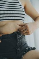 Women body fat belly. Obese woman hand holding excessive belly fat. diet lifestyle concept to reduce belly and shape up healthy stomach muscle. photo