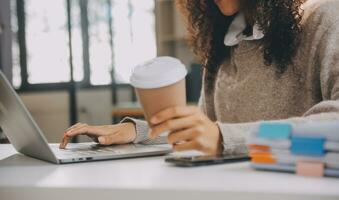 Asian businesswoman working on laptop computer Look for job online, freelance looking and typing on notebook on table, lifestyle of woman studying online photo