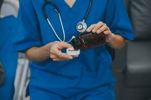 asiático mujer enfermero participación un medicina botella y narración información a asiático mayor mujer antes de administrar medicamento. cuidador visitar a hogar. hogar salud cuidado y enfermería hogar concepto. foto