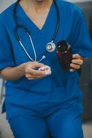 Asian woman nurse holding a medicine bottle and telling information to Asian senior woman before administering medication. Caregiver visit at home. Home health care and nursing home concept. photo