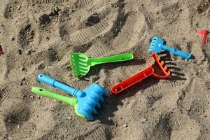 Plastic toy rake in the sandbox. photo