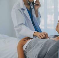 The doctor used a stethoscope to listen to the heartbeat of the man patient, medical checkup concept. photo