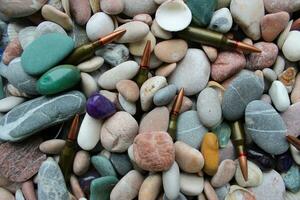 Closeup photo of unitary cartridges partially covered with colored smooth stones