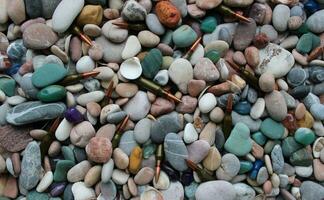 Pattern of bullets scattered between sea pebbles and shells top view photo