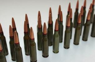 Unitary cartridges with copper alloy shell bullets lined up top view stock photo
