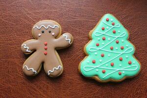 Shortbread Cookies In Shape Of Funny Man And Pine Tree On Brown Leather Surface Concept Design For Greeting Card photo