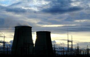 High voltage power lines and cooling towers of giant power station photo