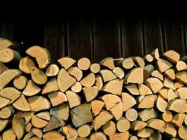 Whole, split in half and chopped oak firewood near the wall of old woodshed photo