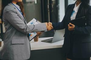 Real estate broker agent and customer shaking hands after signing contract documents for realty purchase, Bank employees congratulate, Concept mortgage loan approval. photo