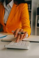 Close up woman work on project sit at desk use laptop and calculator, look at pc screen with diagrams, calculates bills, check financial documents, leads accounting of company, plan investment concept photo