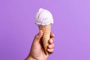 Hand holding ice cream on purple background photo