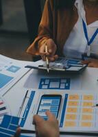 Close up ux developer and ui designer use augmented reality brainstorming about mobile app interface wireframe design on desk at modern office.Creative digital development agency photo