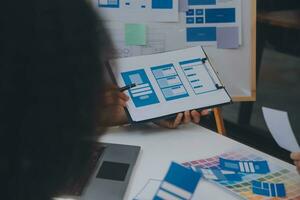 Close up ux developer and ui designer use augmented reality brainstorming about mobile app interface wireframe design on desk at modern office.Creative digital development agency photo