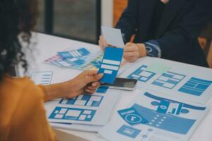 Close up ux developer and ui designer use augmented reality brainstorming about mobile app interface wireframe design on desk at modern office.Creative digital development agency photo