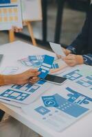 Close up ux developer and ui designer use augmented reality brainstorming about mobile app interface wireframe design on desk at modern office.Creative digital development agency photo