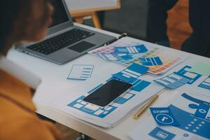 Close up ux developer and ui designer use augmented reality brainstorming about mobile app interface wireframe design on desk at modern office.Creative digital development agency photo