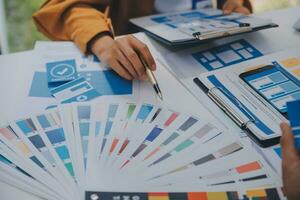 Close up ux developer and ui designer use augmented reality brainstorming about mobile app interface wireframe design on desk at modern office.Creative digital development agency photo