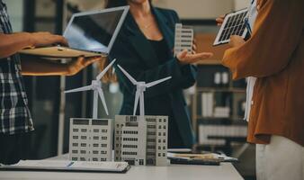 Electrical engineer with businessman discussing new project installation solar cell panel on the roof of building. Alternative energy concept. photo