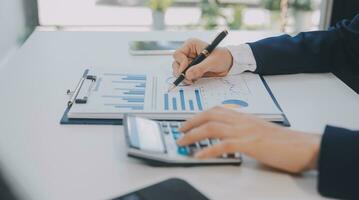 Financial analysts analyze business financial reports on a digital tablet planning investment project during a discussion at a meeting of corporate showing the results of their successful teamwork. photo