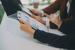 Financial analysts analyze business financial reports on a digital tablet planning investment project during a discussion at a meeting of corporate showing the results of their successful teamwork. photo