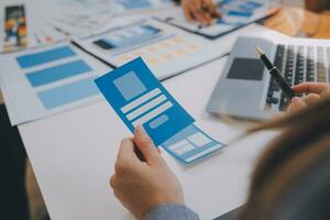 Close up ux developer and ui designer use augmented reality brainstorming about mobile app interface wireframe design on desk at modern office.Creative digital development agency photo