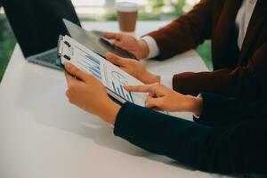 Financial analysts analyze business financial reports on a digital tablet planning investment project during a discussion at a meeting of corporate showing the results of their successful teamwork. photo