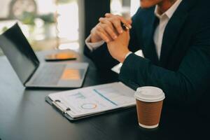 Financial analysts analyze business financial reports on a digital tablet planning investment project during a discussion at a meeting of corporate showing the results of their successful teamwork. photo