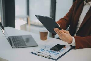 Financial analysts analyze business financial reports on a digital tablet planning investment project during a discussion at a meeting of corporate showing the results of their successful teamwork. photo