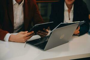 Financial analysts analyze business financial reports on a digital tablet planning investment project during a discussion at a meeting of corporate showing the results of their successful teamwork. photo